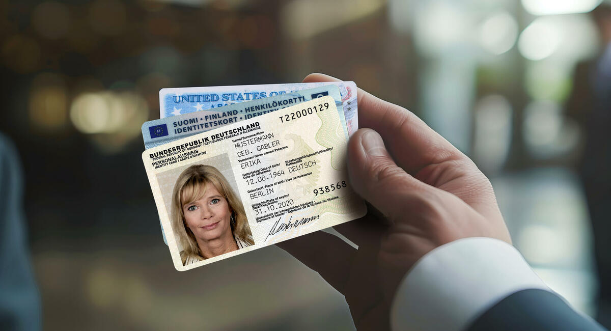 Hand hält drei ausländische Dokumente